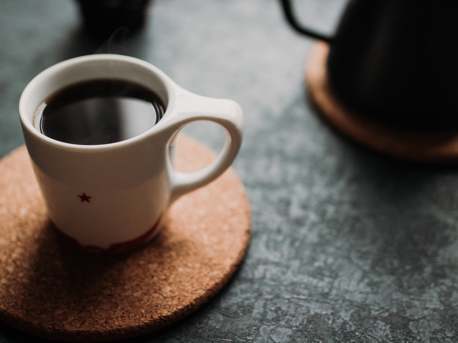 mug of coffee on wooden trivet